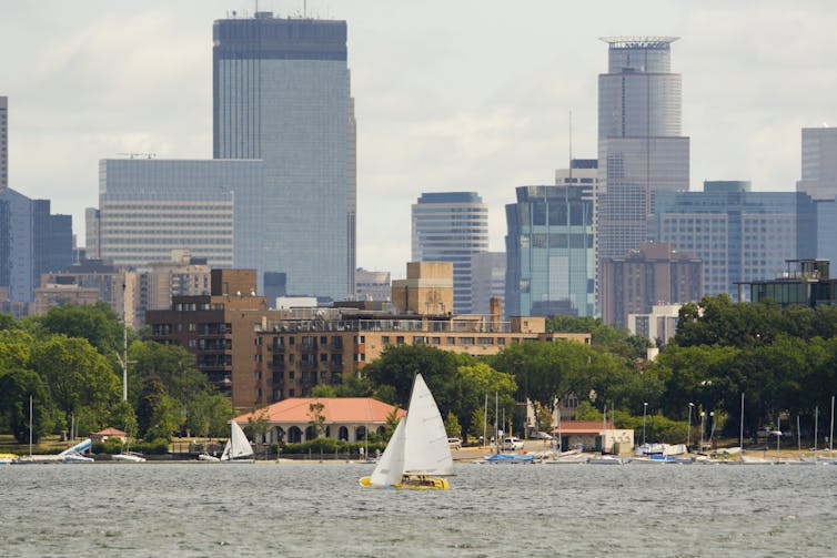 A lake with sailboats and a city skyline in the background